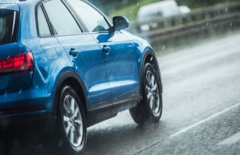 Blue SUV driving in spring rain